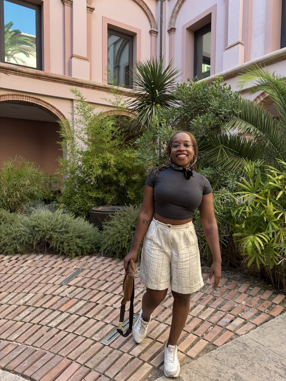 christina in shorts and shirt with bag