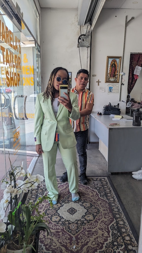 image of christina in green suit infront of mirror